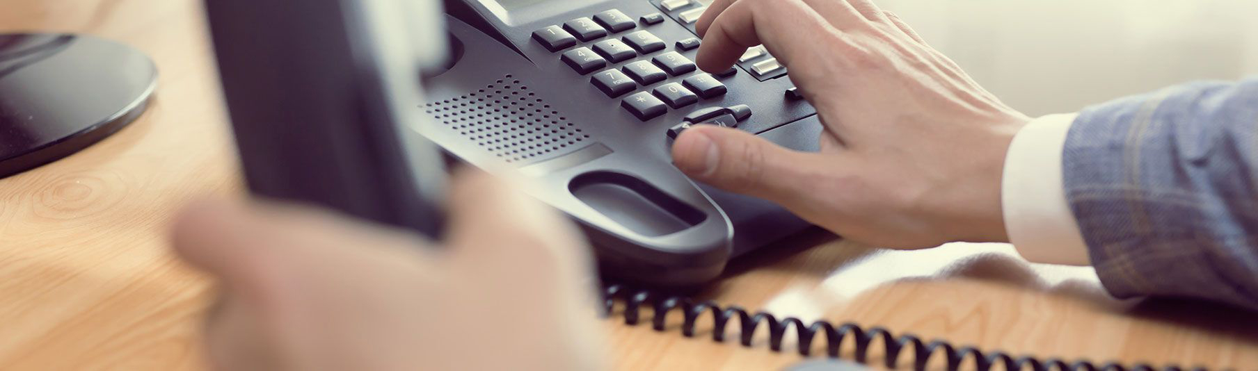 Claims : Close-up of a person's hand about to press the numbers on a landline. 