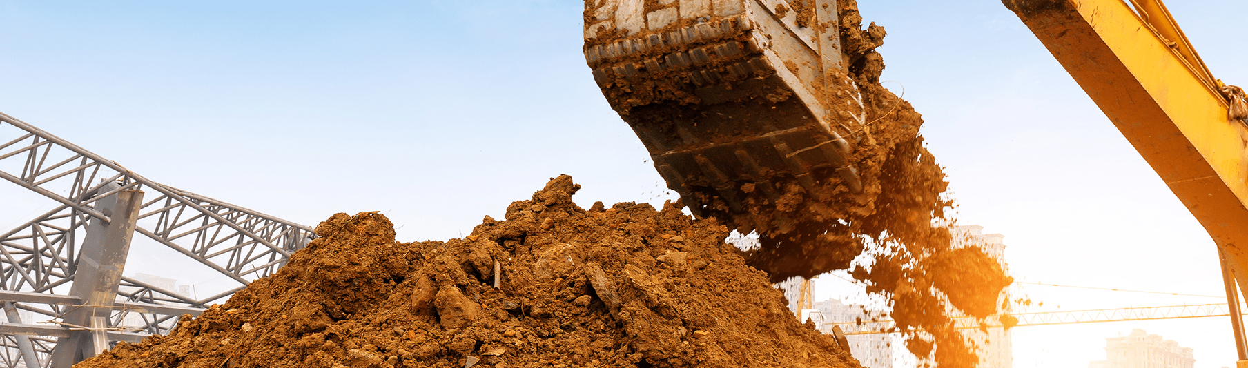 Construction Insurance: A large pile of dirt being scooped up by a bulldozer